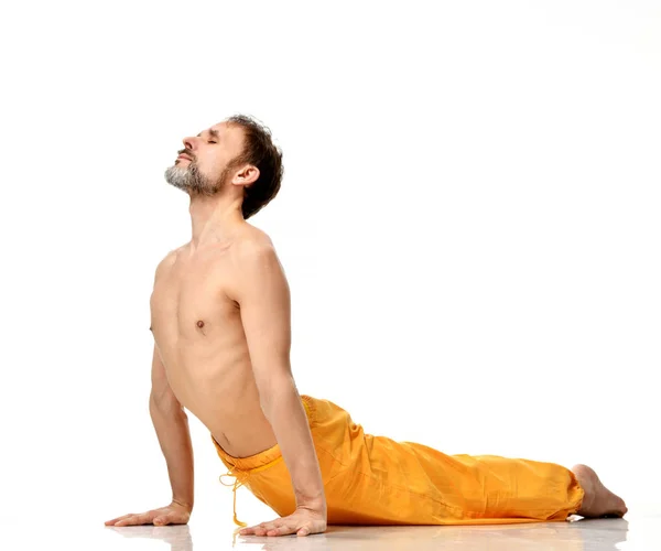 Man practicing yoga doing sport stretching exercises in yellow pants — Stock Photo, Image