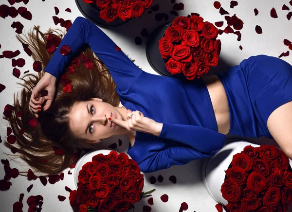 woman lying on red lips sofa couch in blue dress smiling with roses bouquet flowers petals