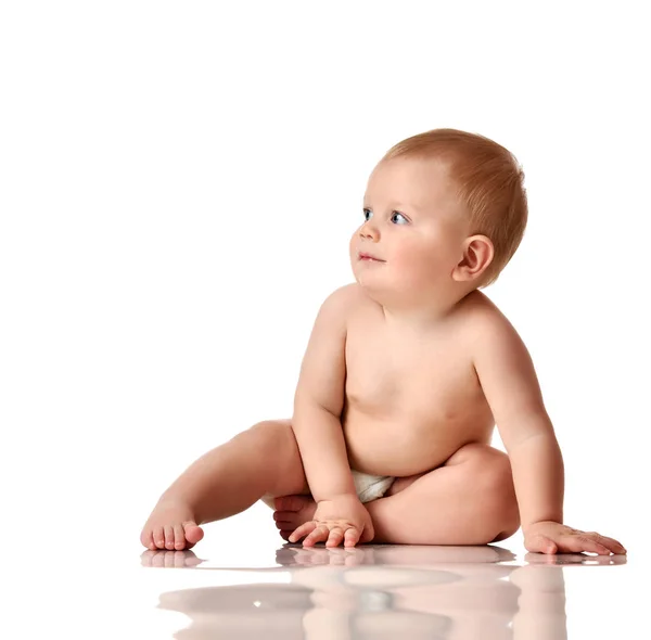 Niño bebé niño pequeño sentado desnudo en pañal con juguete de ladrillo verde mirando hacia arriba —  Fotos de Stock