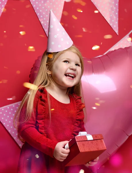 Очаровательная красивая девушка с розовыми шариками, красным подарком и кепкой на день рождения — стоковое фото