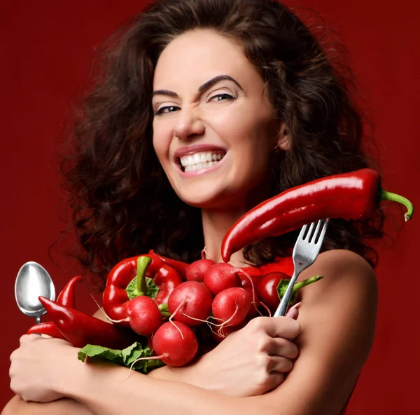 Hezká mladá žena pózuje s čerstvou zeleninou červené ředkvičky chilli papričky zelené listy salátu petržel usmívá — Stock fotografie