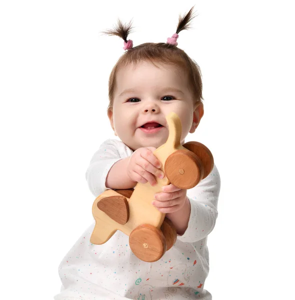 Infant child baby girl toddler sitting playing with eco wood dog toy happy smiling — Stock Photo, Image