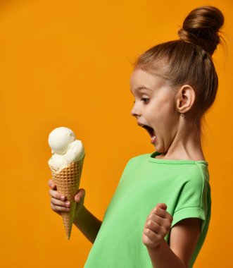 Güzel bebek kız çocuk yalama muz ve vanilyalı dondurma waffle koni içinde yemek