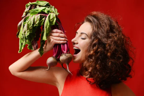 Muito alegre jovem mulher do esporte posando com beterraba fresca folhas verdes . — Fotografia de Stock