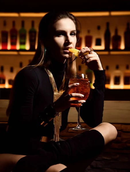 Hermosa moda sexy morena mujer en el bar restaurante relajante beber naranja aperol espíritu cóctel — Foto de Stock