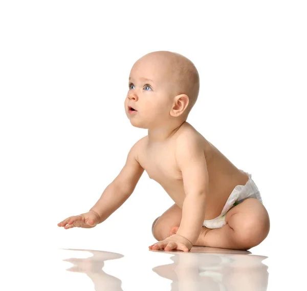 Toddler chłopiec niemowlę dziecko siedząc nago w pieluchy przeszukiwanie szczęśliwy uśmiechający się na białym tle — Zdjęcie stockowe