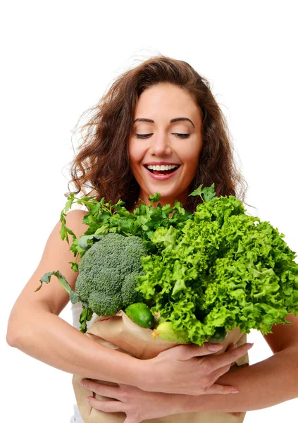 Mujer joven sostiene bolsa de compras de papel de supermercado llena de verduras verdes frescas —  Fotos de Stock