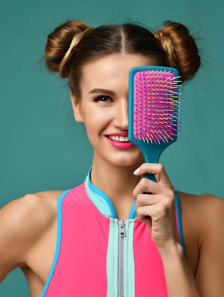 Joven mujer feliz cerrar los ojos con rosa y azul cepillo de peine de pelo grande sonriendo — Foto de Stock