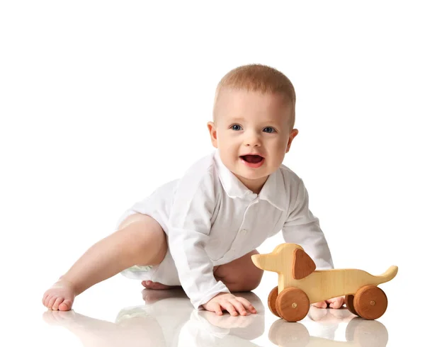 Kind kind baby jongen peuter zitten spelen met eco houten hond speelgoed gelukkig lachend — Stockfoto