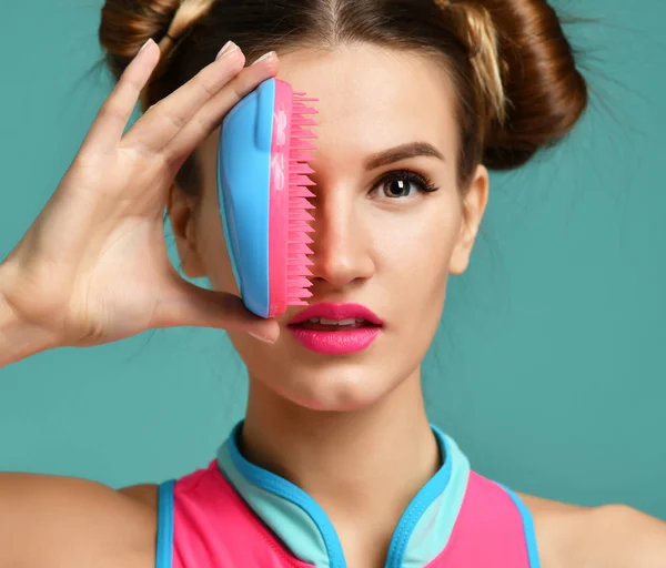 Feliz moda morena mujer ojo cercano con colorido rosa azul popular peine cepillo — Foto de Stock