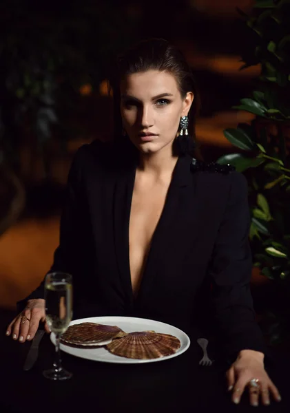 Hermosa mujer morena moda sexy en el restaurante interior caro beber champán y comer vieiras crudas — Foto de Stock