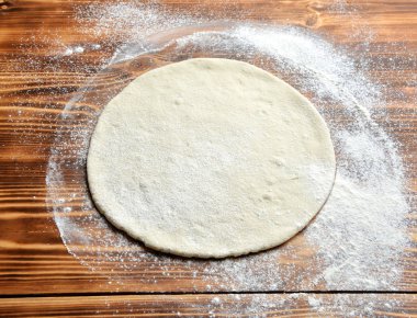 İtalyan pizza hazırlık sürecinde rustik ahşap masa üzerinde pişirme