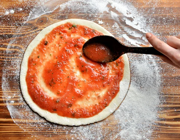 Processo de preparação de pizza italiana em mesa de madeira rústica . — Fotografia de Stock