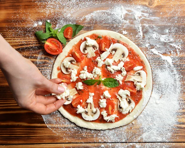 Processo de preparação de pizza italiana em mesa de madeira rústica. Massa de farinha de pizza e ingredientes cogumelos champignon — Fotografia de Stock