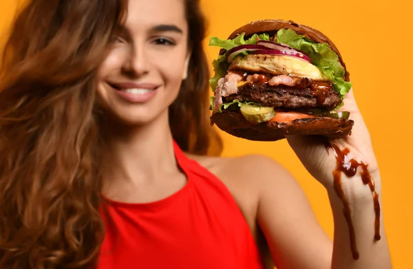 Vrouw houd barbecue Hamburger sandwich met hongerige mond op geel — Stockfoto