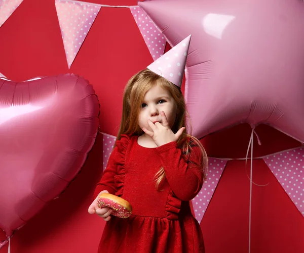 Adorable pretty girl with pink balloons and red present gift and birthday cap — Stock Photo, Image