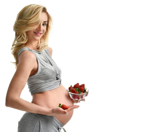 Mooie zwangere vrouw met grote buik aardbeien eten — Stockfoto