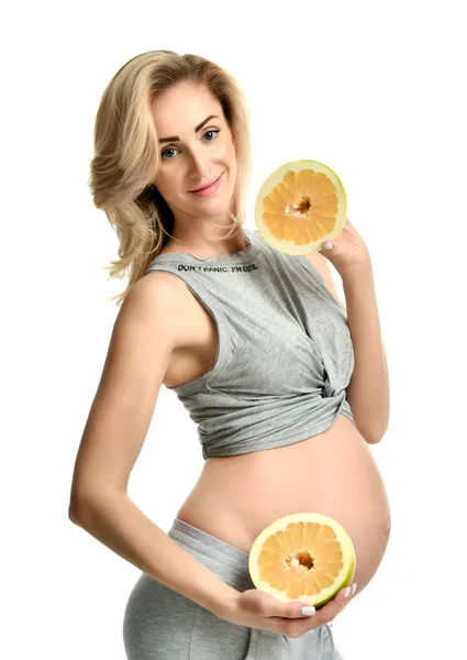 Hermosa mujer embarazada sostiene dos mitad de los frutos de pomelo — Foto de Stock