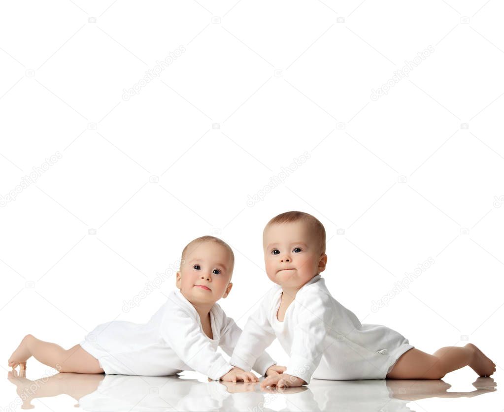 Two twin sisters infant child baby girls toddler sitting in white shirt happy smiling