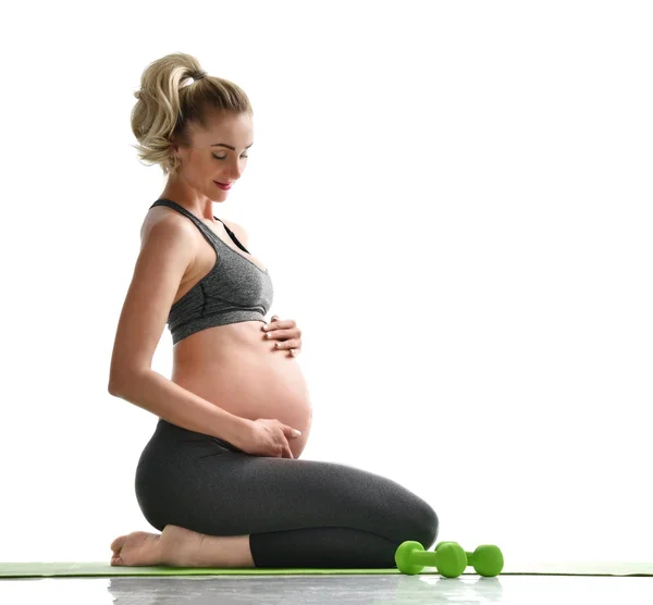 Gravid kvinna gör sport stretching övningar grön vikter. Graviditet moderskap förväntan hälsosamt liv och vikt kontroll koncept — Stockfoto