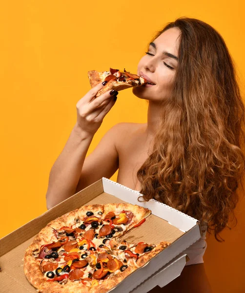 Νεαρή όμορφη γυναίκα τρώνε κομμάτι πίτσα πεπερόνι και κρατήστε ολόκληρη πίτσα στο πλαίσιο — Φωτογραφία Αρχείου
