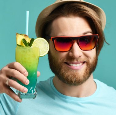 Kırmızı güneş gözlüğü ve şapka genç adam tutun margarita kokteyl içki suyu mutlu gülümseyerek 