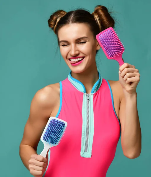 Closeup portret van gelukkig lachende mode brunette vrouw met kleurrijke roze en witte grote vierkante kam haarborstels — Stockfoto