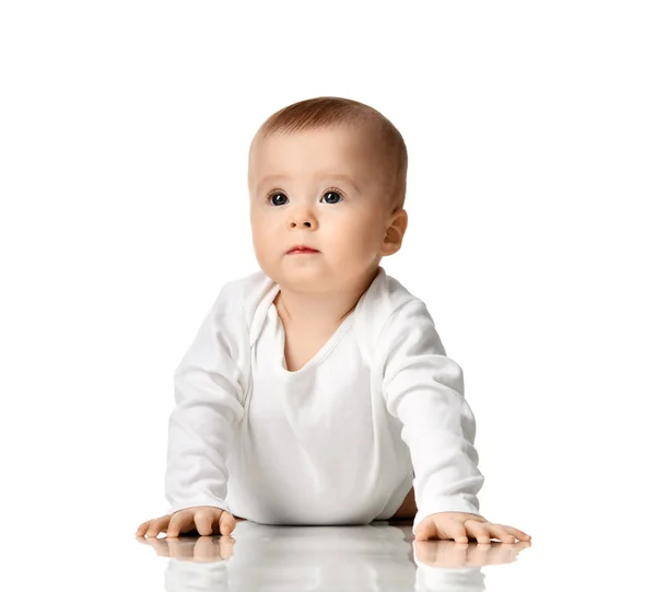 Niño niño de 7 meses niña pequeña acostada en camisa blanca mirando a la esquina —  Fotos de Stock