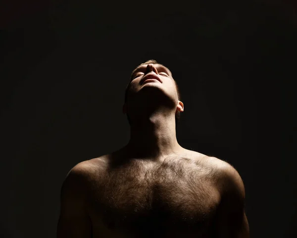 Closeup portrait of sexy handsome topless male model looking up on dark — Stock Photo, Image