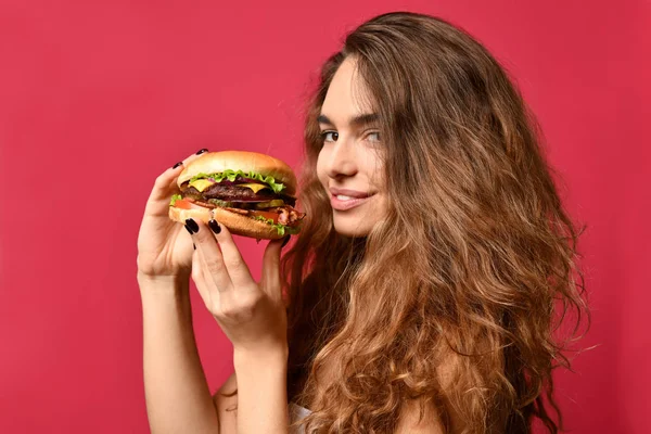 Mulher segurar churrasco hambúrguer sanduíche com fome boca no fundo vermelho rosa — Fotografia de Stock