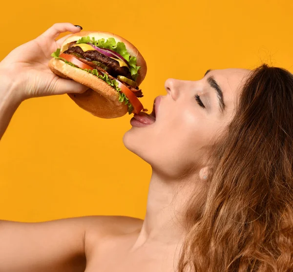 Nő enni burger szendvics éhes száj, sárga háttér — Stock Fotó