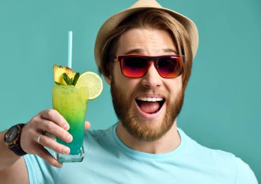 Kırmızı güneş gözlüğü ve şapka genç adam tutun margarita kokteyl içki suyu mutlu gülümseyerek 