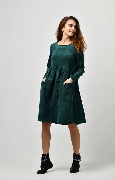 Jovem bela mulher posando em novo vestido verde de inverno casual em um cinza — Fotografia de Stock