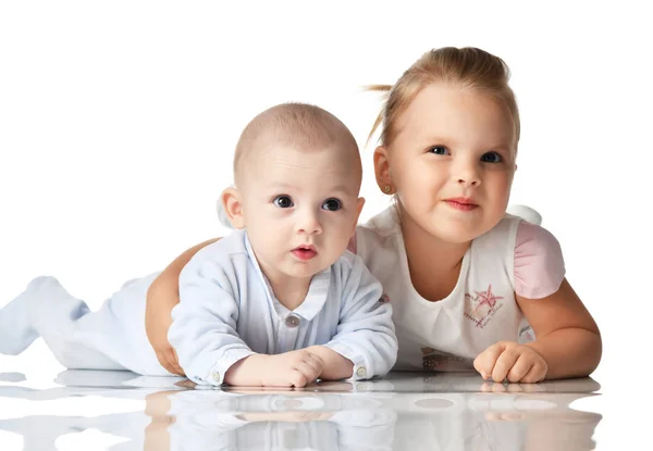 Kız ve erkek kardeşim. 4 aylık erkek bebek bebek ve iki yıl yaşlı kız yürümeye başlayan çocuk yalancı birlikte sarılma mutlu gülümseyerek — Stok fotoğraf