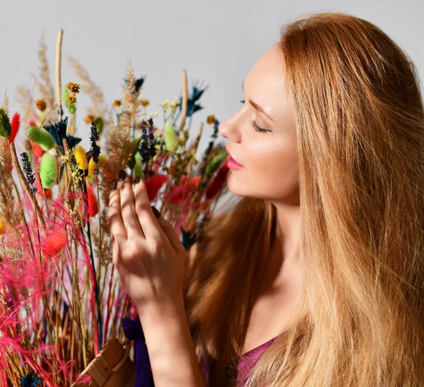 Beautiful woman with bouquet of wild flowers on grey background — Stock Photo, Image