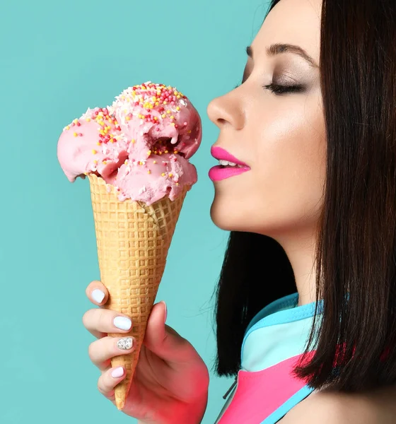 Jonge vrouw in roze vest zwembroek houd aardbei dessert van ijs op moderne lichte blauwe achtergrond — Stockfoto