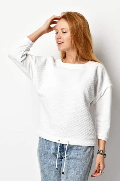 Mujer hermosa joven posando en un nuevo suéter blanco casual mirando a la esquina — Foto de Stock