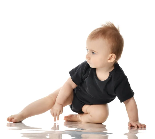 9 maand baby kind baby meisje peuter zit in donker grijs shirt te kijken naar de hoek geïsoleerd op een witte — Stockfoto