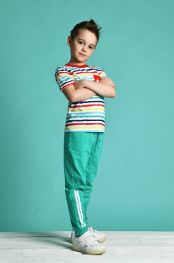 Şeritler rahat gömlek olumlu tutum mavi nane arka plan üzerinde duran genç çocuk