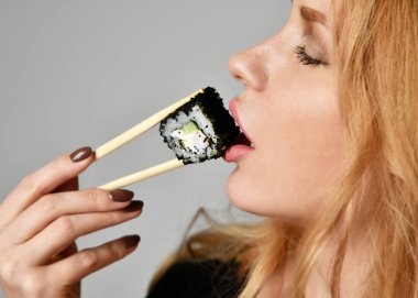 Suşi kız kadınla eller üzerinde açık bir gri gülümseyen suşi rulo hold 