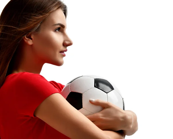 Eine Spielerin in roter Uniform hält einen Fußballball in der Hand und blickt in die Nahaufnahme auf weißem Hintergrund — Stockfoto