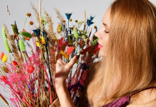 Hermosa sonrisa de mujer con ramo de flores silvestres primer plano retrato feliz sonrisa vista superior en gris —  Fotos de Stock