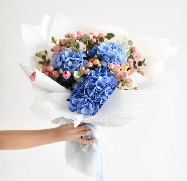 女性手保持青いアジサイの花とピンクのバラの花束 — ストック写真