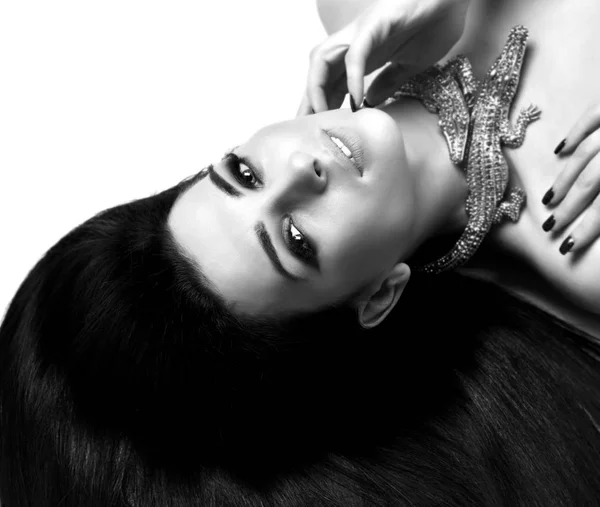 Giovane bella donna bruna sdraiata sul pavimento indossare costosi gioielli in coccodrillo oro con i capelli lunghi — Foto Stock