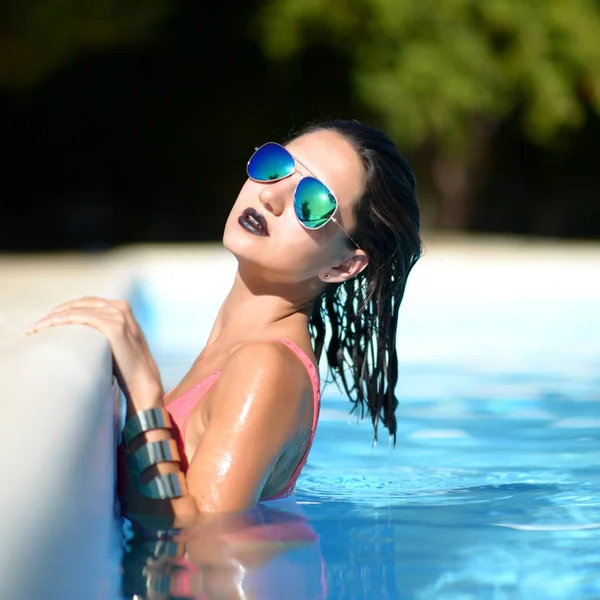 Kvinna avkopplande i blå lyx poolen fritid på vit natursten — Stockfoto