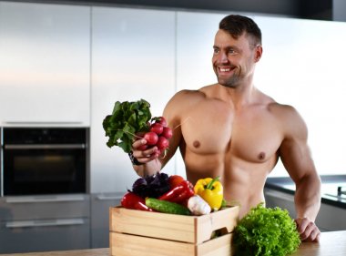 kas spor adam yiyecek sebze ile mutfak üzerinde ayakta köşe gülümseyen arıyorum elinde turp tutun