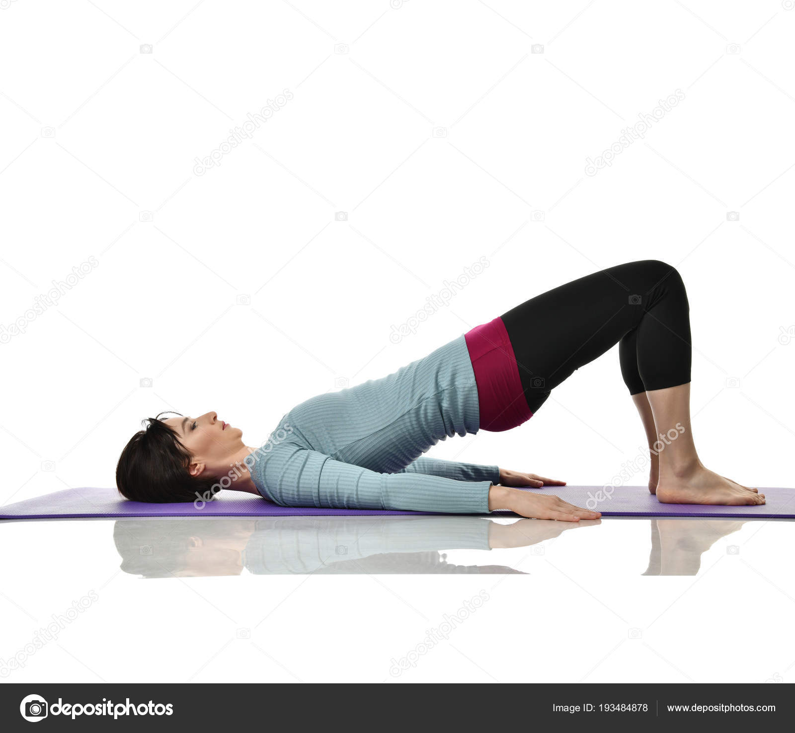 Mother woman exercising doing postnatal workout. Female fitness instructor  holds legs in gym and workout exercises Stock Photo by ©dml5050 193484878