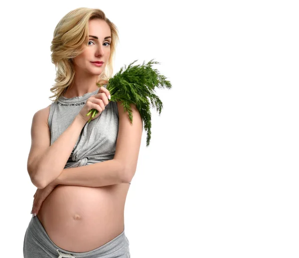Hermosa mujer embarazada sostiene eneldo orgánico para ensalada. Embarazo maternidad expectativa alimentación saludable —  Fotos de Stock