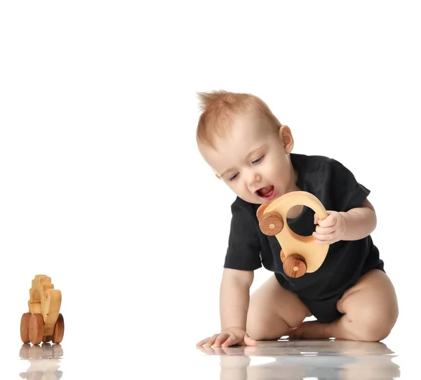8 maand baby kind baby meisje peuter zit in zwarte shirt spelen met houten speelgoed — Stockfoto