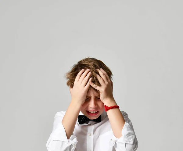 Young school boy screaming and crying close up on gray — Stock Photo, Image